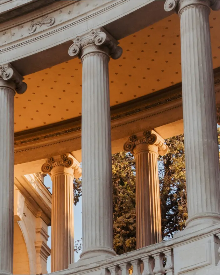 Patrimoine Capital Conseil — la galerie à colonnes du Palais Longchamp, dorée par la lumière du soir